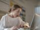 Woman in White Long Sleeve Shirt Using Silver Laptop Computer