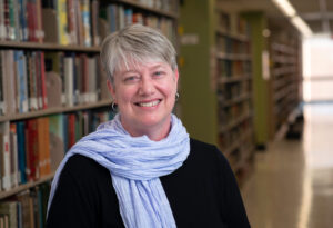 Photo of Kirsten Clark with bookshelves in background